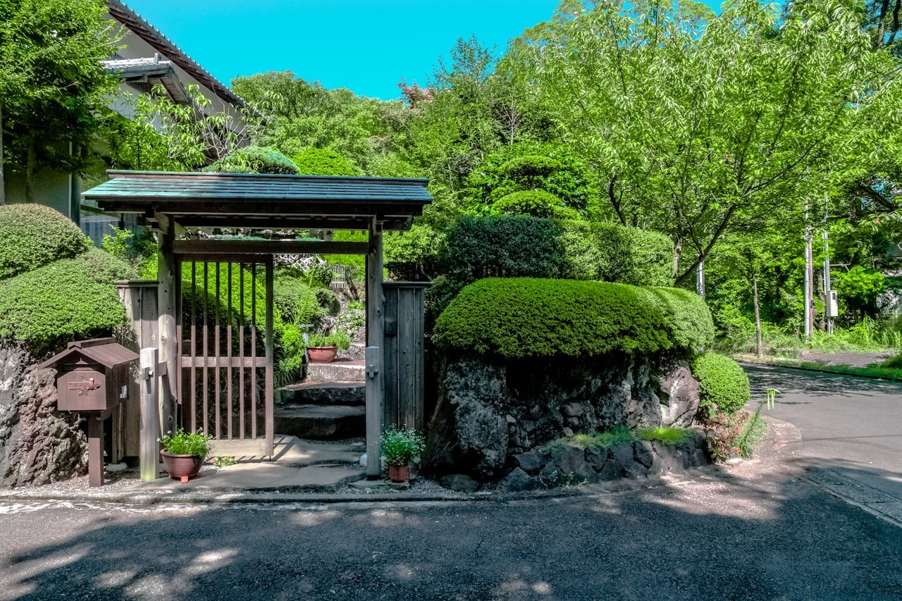 A tranquil garden entrance with lush greenery and traditional design features.